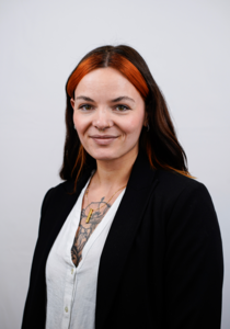 Porträtfoto eines weiblichen Teammitglieds mit dunklen Haaren und weißer Bluse.